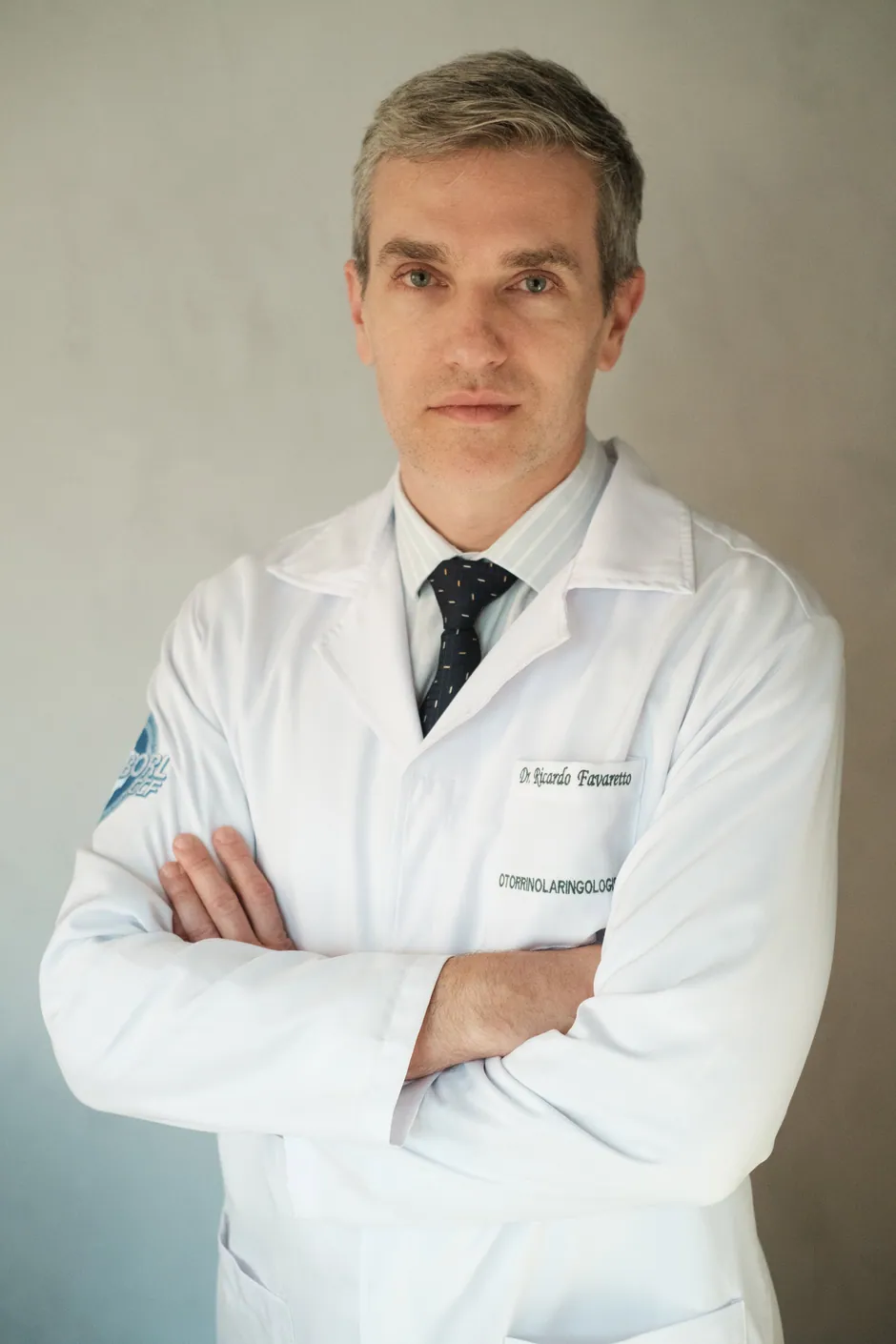 Dr. Ricardo Favaretto de jaleco branco, otorrinolaringologista e cirurgião cérvico-facial em Florianópolis